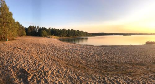 a sandy beach next to a body of water at MAJKÓWKA in Łąkie