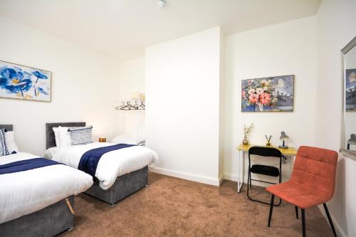 a bedroom with two beds and a desk and a chair at Stylish Suite with free parking in Manchester