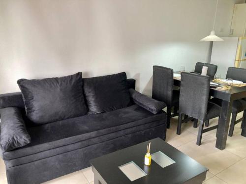 a living room with a black couch and a table at 5-Súper Dpto en Morón centro in Morón