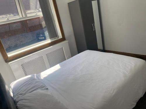 a white bed in a room with a window at Pure luxury APT2 in Wolverhampton