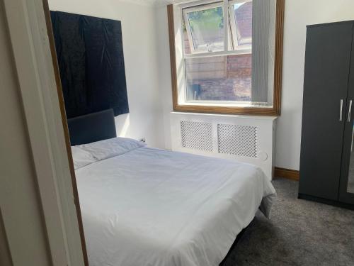 a bedroom with a white bed and a window at Pure luxury APT2 in Wolverhampton