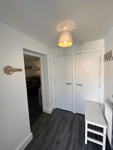 a room with white walls and a table and a lamp at Amo Mews House - Central, Private Patio & Free Parking in Worthing