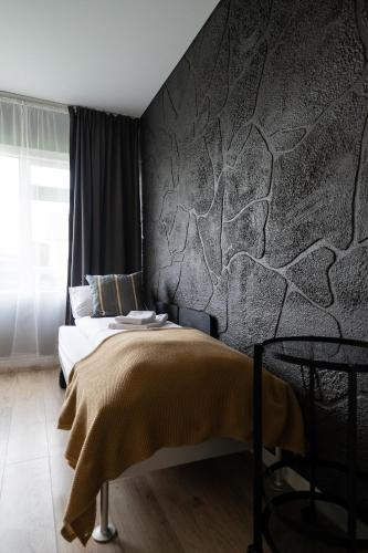 a bedroom with a bed and a stone wall at Hótel Blönduós in Blönduós