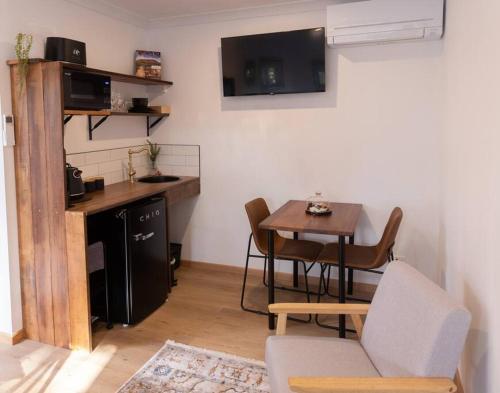a living room with a kitchen and a table with chairs at Burnie Unit - The Cape in Burnie