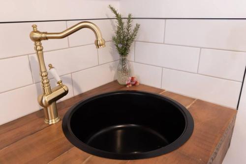 a black sink with a gold faucet in a bathroom at Burnie Unit - The Cape in Burnie