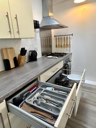 a kitchen with an open drawer with utensils in it at Amo Mews House - Central, Private Patio & Free Parking in Worthing