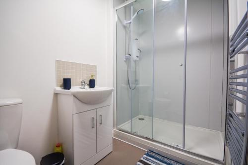 a bathroom with a shower and a sink at Stylish One-bedroom with Free Parking Sleeps 4 in Manchester