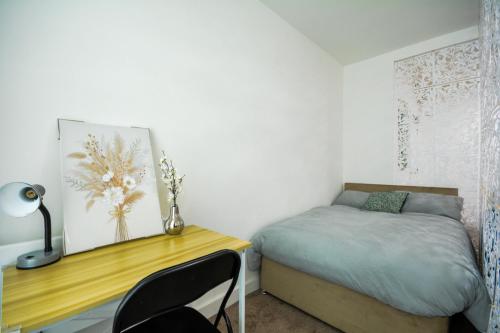 een kleine slaapkamer met een bureau en een bed bij Stylish One-bedroom with Free Parking Sleeps 4 in Manchester