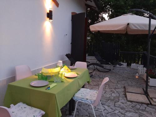 una mesa verde con sillas y una sombrilla en Patrizia's Maison, en Ripatransone