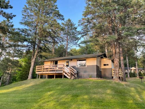 una cabaña en el bosque con un gran patio en Hanging Horn Lakeside Resort, en Moose Lake