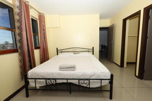 a small bedroom with a bed in a room at Tropical Plaza Apt in Nadi