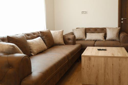 a living room with a brown couch and a coffee table at GOLDEN VIEW Sokobanja in Soko Banja