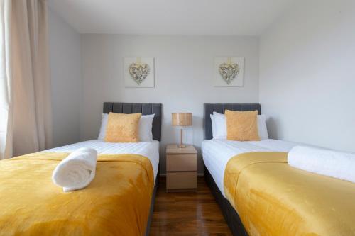 two beds sitting next to each other in a bedroom at Lovely 2 Bedroom Condo with River & City View in North Woolwich