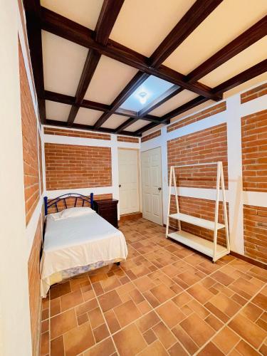 a bedroom with a bed and a brick wall at Villa Bonita Los Naranjos in Los Naranjos