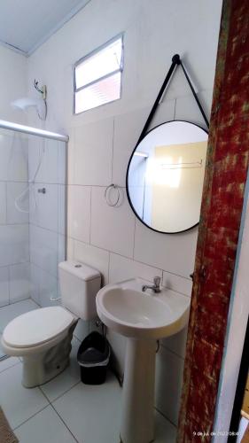 a bathroom with a toilet and a sink and a mirror at Pousada Siriba in Caravelas