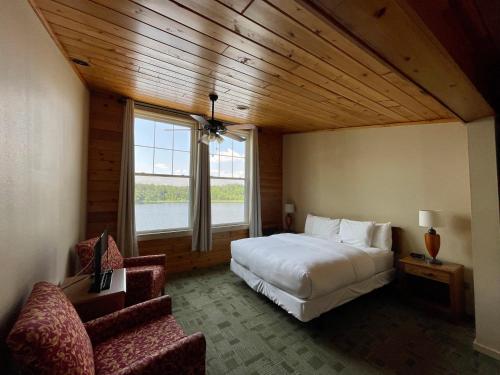 1 Schlafzimmer mit einem großen Bett und 2 Stühlen in der Unterkunft Hanging Horn Lakeside Resort in Moose Lake