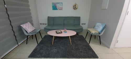 a room with a table and chairs and a couch at Depto. Condominio La Herradura, Coquimbo in Coquimbo