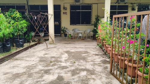 a patio with potted plants and a table and chairs at Homestay Kasturi Teluk Kalong Kemaman in Kijal