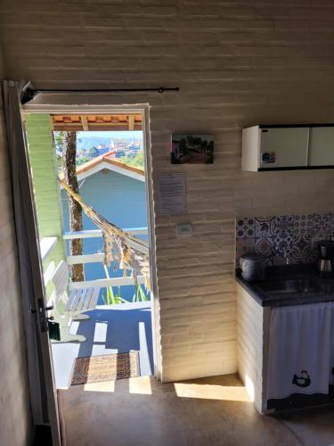 Une porte ouverte s'ouvre sur une cuisine dotée d'un balcon. dans l'établissement Pousada Recanto João de Barro, à Cunha
