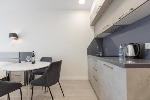 a kitchen with a table and chairs in a room at The SPOT apartments - Orbi Beach Tower in Batumi