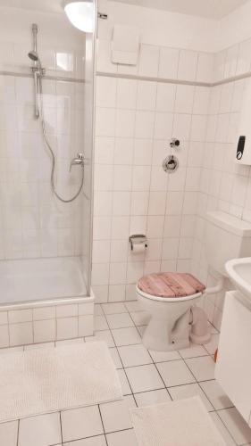 a white bathroom with a toilet and a shower at Wohnung in Bremen Blumenthal in Bremen