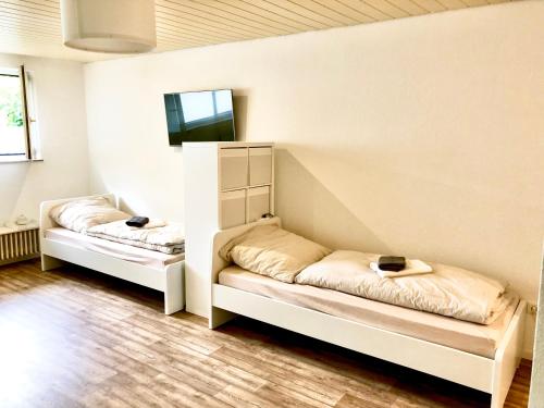 two beds in a room with white walls at Wohnung in Bremen Blumenthal in Bremen