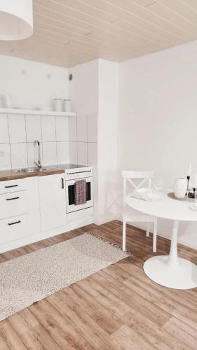 a white kitchen with a white table and a white counter top at Wohnung in Bremen Blumenthal in Bremen