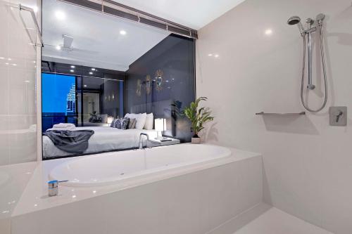 ein weißes Badezimmer mit Badewanne und ein Schlafzimmer in der Unterkunft Three Bedroom, Level 57 - Circle on Cavill - Self Contained, Privately Managed Apartments in Gold Coast