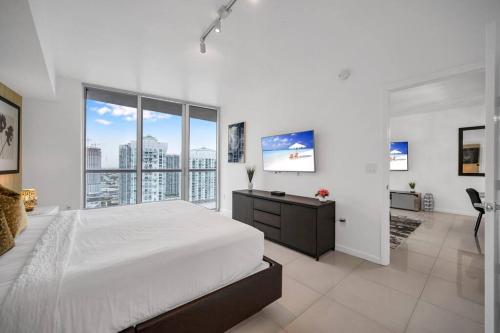 1 dormitorio blanco con 1 cama grande y ventanas grandes en 38th floor W residence with amenities, en Miami