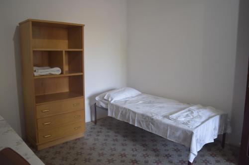 1 dormitorio con 1 cama y armario de madera en Hotel La Mansión, en Villarrica