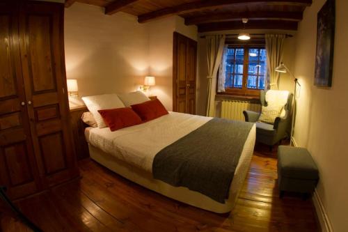 een slaapkamer met een bed, een stoel en een raam bij El Tarter - Andorra in El Tarter