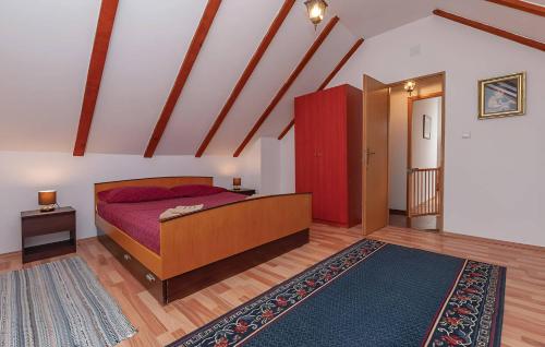 een slaapkamer met een bed en een rode kast bij NEW! Authentic Stone House In National Park Krka in Puljane