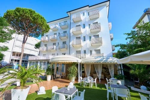 a hotel with tables and chairs in front of a building at Hotel Bruna B&B in Milano Marittima