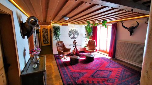 sala de estar con alfombra roja en el suelo en Gasthof Geronimo, en Weissbach bei Lofer
