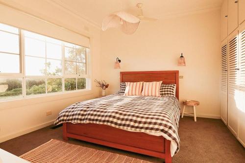 a bedroom with a bed and two windows at Bluey in Warrnambool