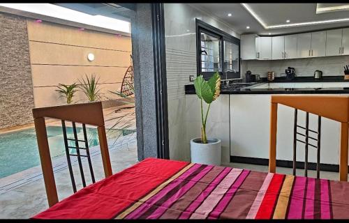 a kitchen with a table and two chairs and a kitchen with a kitchen at Villa piscine sans vis à vis vue mer in Tangier