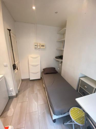une petite chambre avec un lit et un bureau dans l'établissement Small studio near Eiffel Tower, à Paris