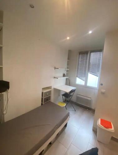 une chambre avec un lit, un bureau et une fenêtre dans l'établissement Small studio near Eiffel Tower, à Paris