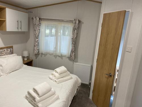 a bedroom with a bed with white towels on it at 16 Leaf Lane Country Retreat in Newton on the Moor