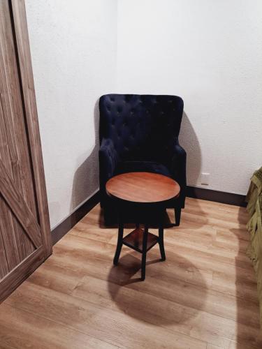 a black chair with a wooden table in a room at Dunes Motel - Bend in Bend