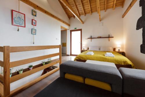 a bedroom with a yellow bed and a couch at Casas da Pedreira in Lajes do Pico