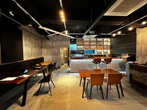 a restaurant with wooden tables and chairs and a counter at Artist Village Apartments Kochi in Kochi