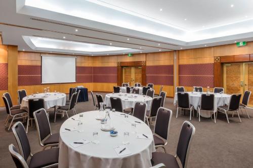 a conference room with tables and chairs and a projection screen at View Sydney in Sydney