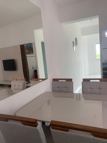 een kamer met stoelen, een tafel en een spiegel bij Ed. Odilon Vieira ap.205 in Vitória da Conquista