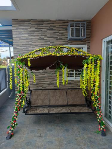 a bench covered in yellow and green flowers at DULLI TRANSIENT HOUSE in Lipa