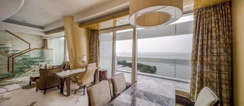 a dining room with a table and chairs and a large window at Sheraton Huzhou Taihu Lake Hot Spring Resort & Spa in Huzhou