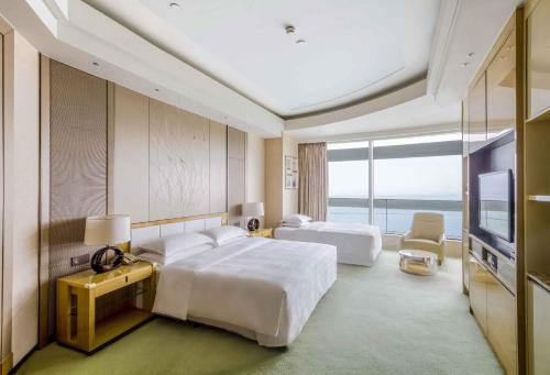 una camera d'albergo con due letti e una televisione di Sheraton Huzhou Taihu Lake Hot Spring Resort & Spa a Huzhou