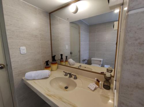 a bathroom with a sink and a large mirror at Inti Llaqta Hotel & Suites in Lima