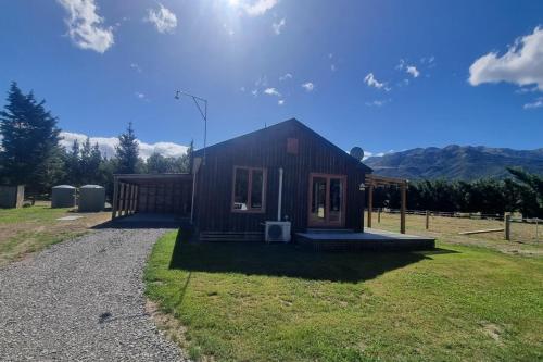 a small house sitting on top of a grass field at Sherwood Ranch Cottages - 403 Woodbank Road in Hanmer Springs