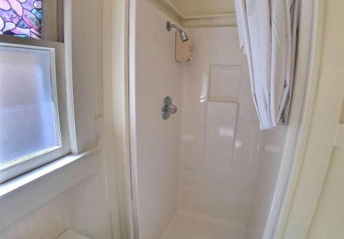 ein weißes Badezimmer mit Dusche und Fenster in der Unterkunft Tuscany Dream Rock Cottage/#8 in Eureka Springs